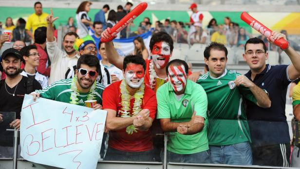 Eine Gruppe Fußballfans feuert ihre Mannschaft im Stadion an.