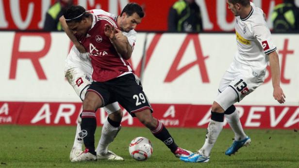 Zwei Fußballspieler kämpfen um den Ball während eines Spiels.