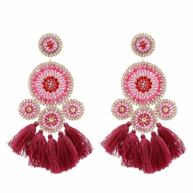 Zwei rote und rosa Ohrringe mit Quasten vor einem weißen Hintergrund.