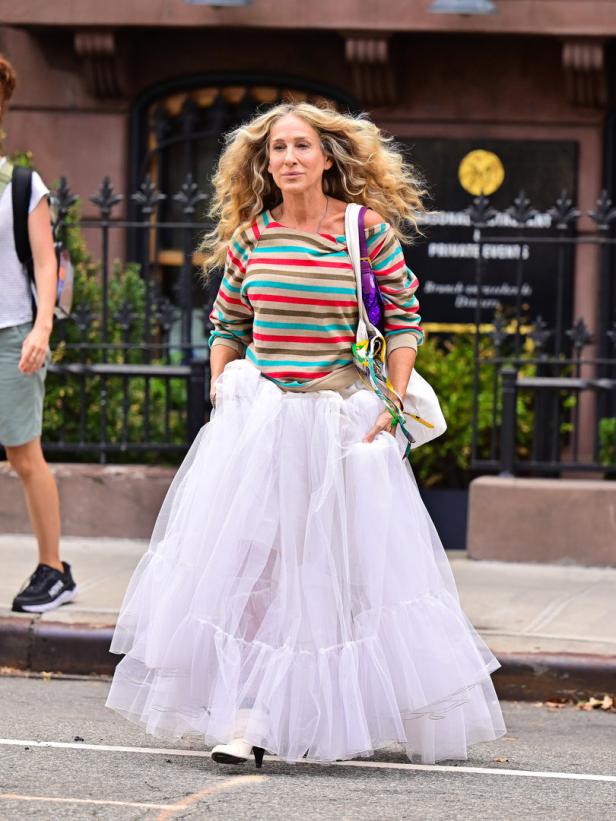 Sarah Jessica Parker in einem gestreiften Oberteil und einem weißen Tüllrock auf einer Straße.