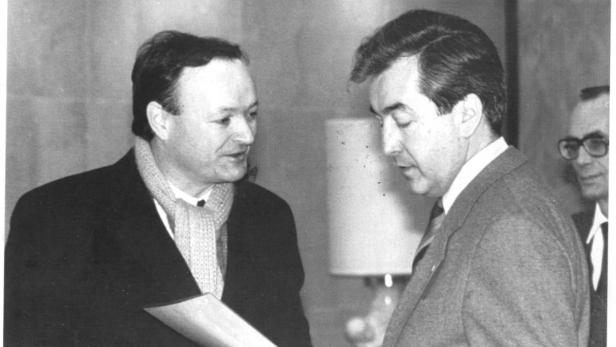 Zwei Männer in Anzügen unterhalten sich in Schwarzweiß.