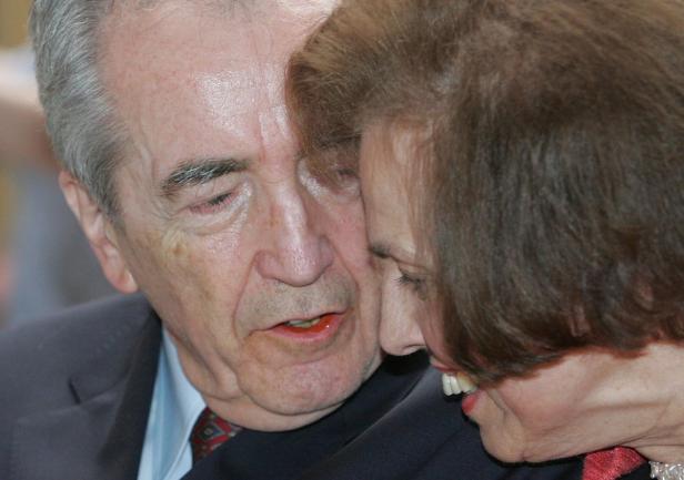 Ein älterer Mann und eine Frau stehen eng beieinander.