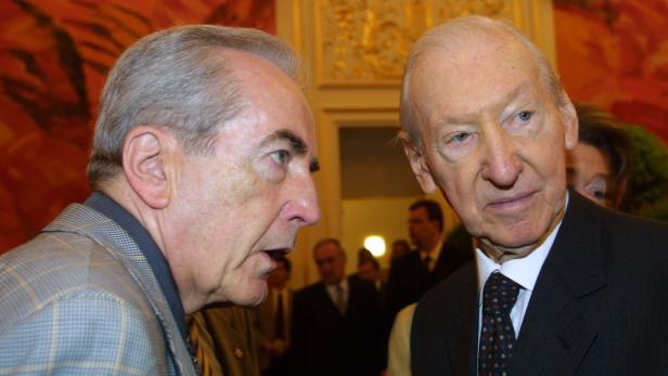 Zwei ältere Männer unterhalten sich auf einer Veranstaltung.