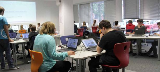 Schüler arbeiten in einem Computerraum an ihren Laptops.
