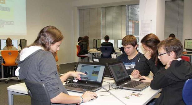 Schüler arbeiten in einem Computerraum an ihren Laptops.