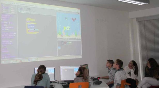 Eine Gruppe von Schülern arbeitet mit der Programmiersprache Scratch im Computerraum.