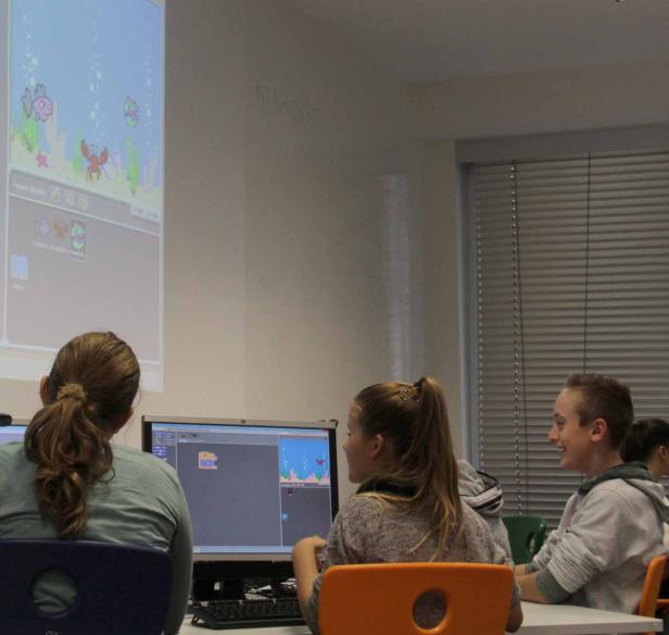 Schüler arbeiten an Computern mit einer Unterwasser-Animation auf dem Bildschirm.