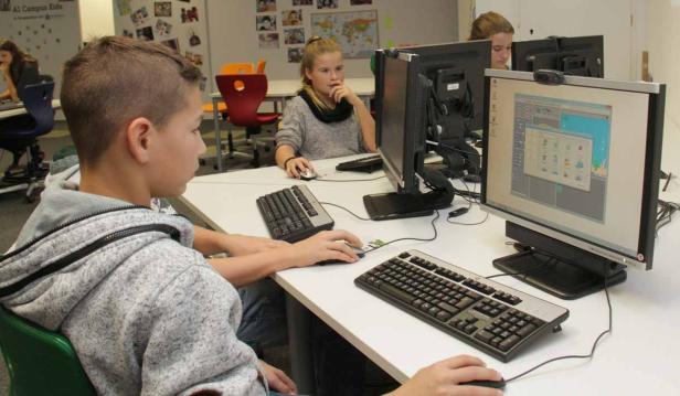 Schüler arbeiten in einem Computerraum an ihren Computern.