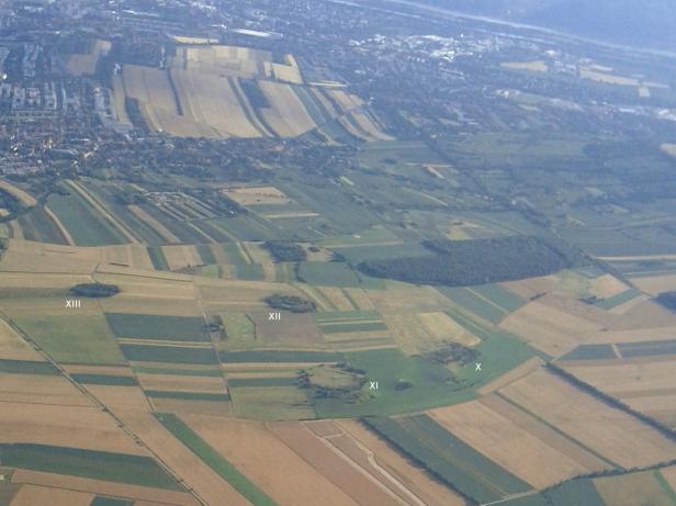 Luftaufnahme von Feldern und einer Stadt im Hintergrund.