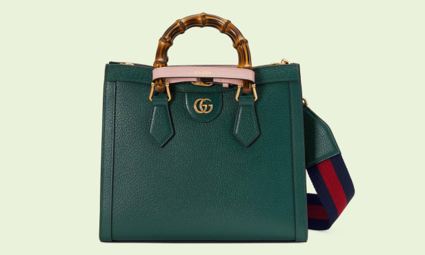 Eine grüne Gucci Bamboo Handtasche mit Bambusgriff und gestreiftem Schulterriemen.