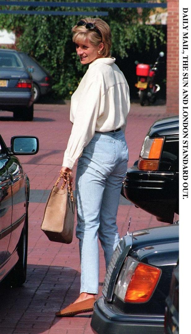 Prinzessin Diana mit Handtasche und Jeans steht neben einem Auto.
