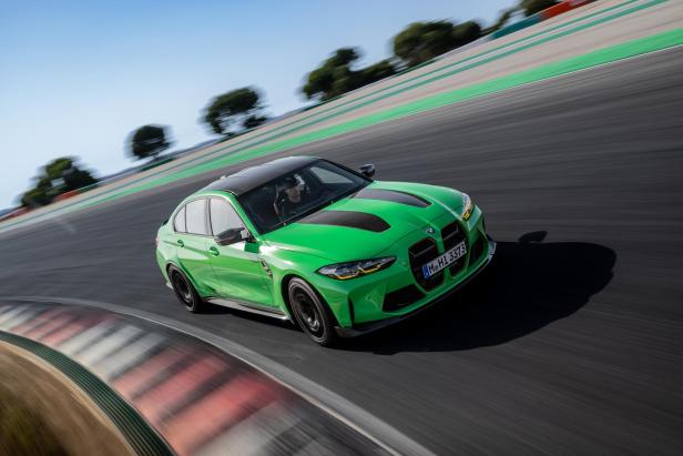 Ein grüner BMW M3 fährt auf einer Rennstrecke.