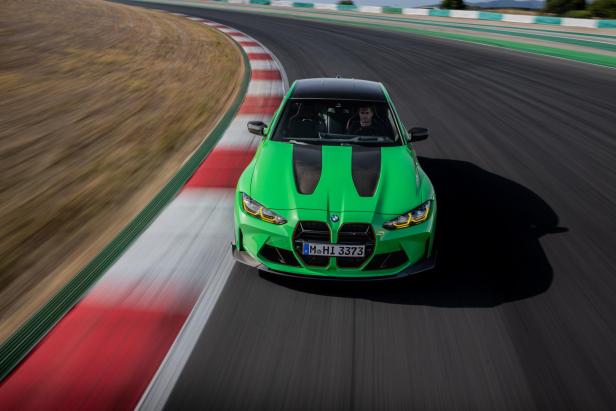 Ein grüner BMW M3 fährt auf einer Rennstrecke.