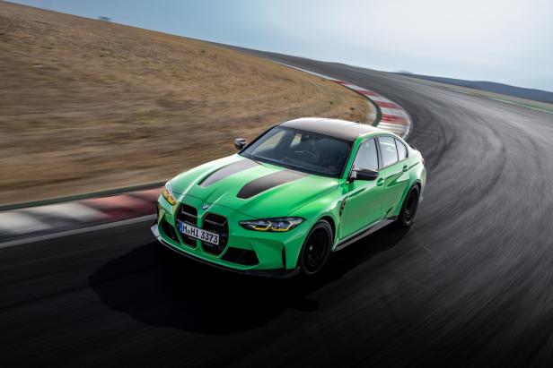 Ein grüner BMW M3 fährt auf einer Rennstrecke.