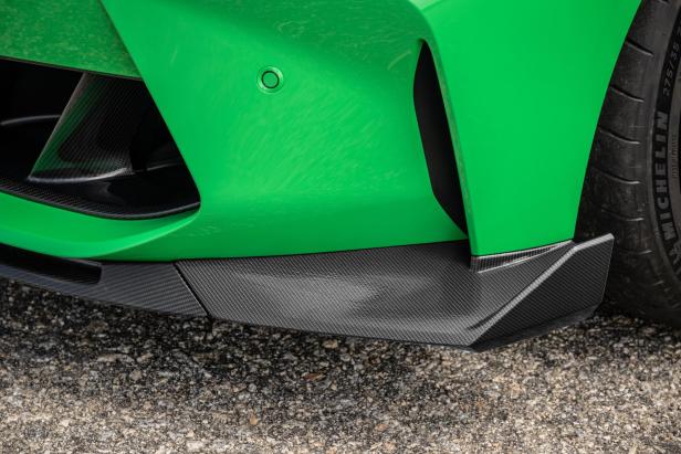 Detailansicht der grünen Frontpartie eines Autos mit Carbon-Spoiler.
