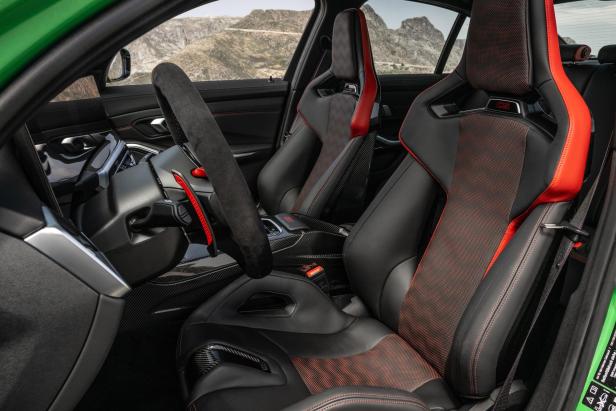 Das Interieur eines BMW M3 CS mit schwarzen Ledersitzen und roten Akzenten.