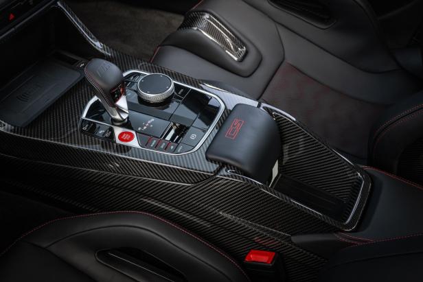 Detailaufnahme der Mittelkonsole eines BMW M3 CS mit Carbonfaser-Akzenten.