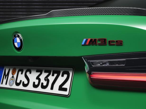 Detailansicht des Hecks eines grünen BMW M3 CS mit Carbon-Spoiler.