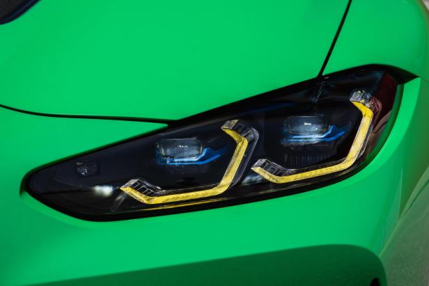 Detailansicht des Scheinwerfers eines grünen BMW M3.