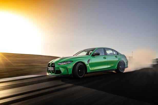 Ein grüner BMW M3 driftet auf einer Rennstrecke.