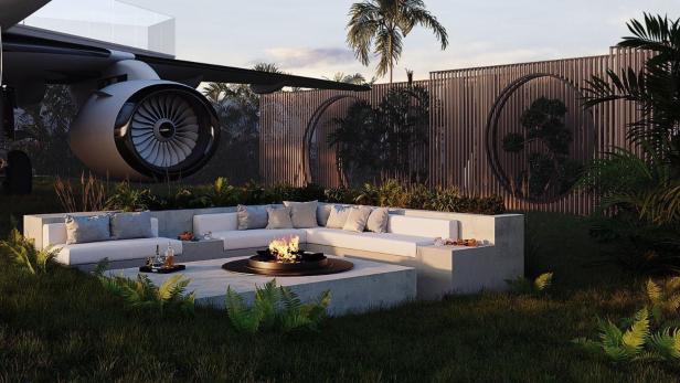Ein Garten mit einer Sitzecke, einem Feuerkorb und dem Triebwerk eines Flugzeugs.