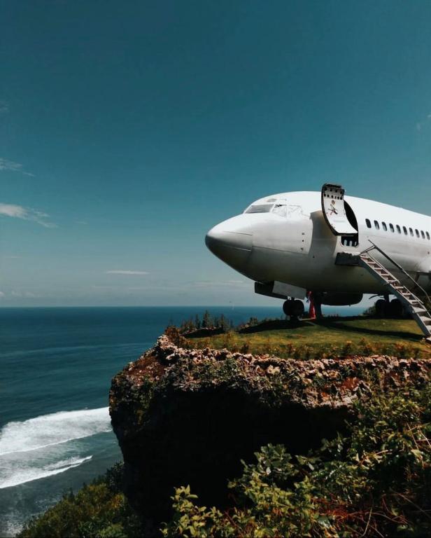 Ein Flugzeug steht auf einer Klippe mit Blick auf das Meer.