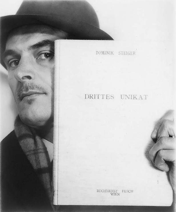 Ein Mann mit Hut präsentiert das Buch „Drittes Unikat“ von Dominik Steiger.