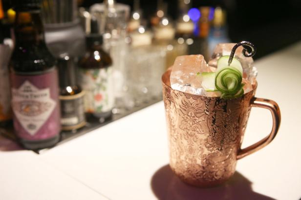 Ein Moscow Mule in einem verzierten Kupferbecher mit Eis und Gurkendekoration.