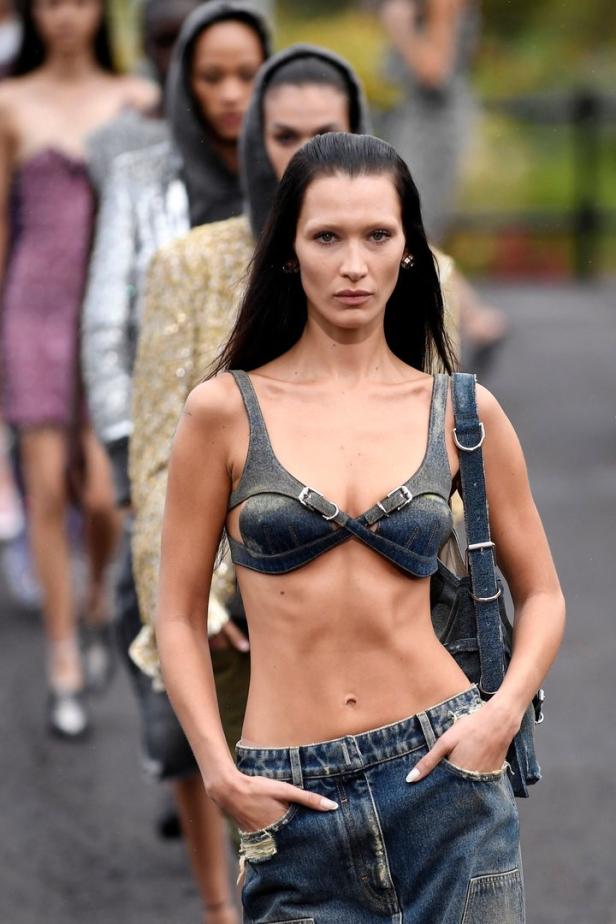 Bella Hadid läuft in einem Jeans-Bralette und Rock über einen Laufsteg.