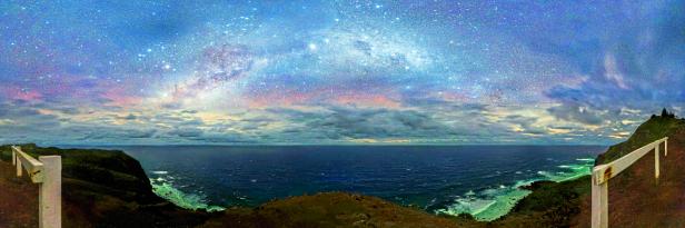 Blick auf das Meer und den Sternenhimmel von einer Küstenklippe aus.