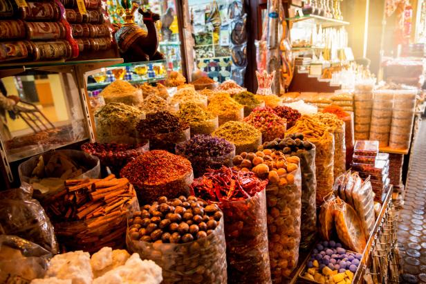 Eine große Auswahl an Gewürzen und Trockenfrüchten auf einem Markt präsentiert.