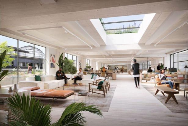 Ein heller, offener Büroraum mit Sitzbereichen und Arbeitsplätzen unter einem Glasdach.