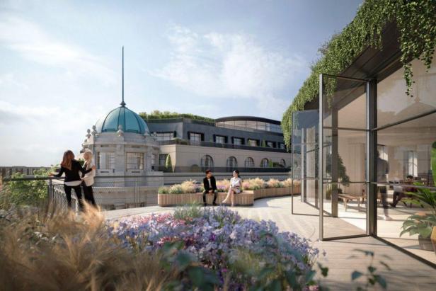 Eine Dachterrasse mit Blumenbeeten und Blick auf ein Gebäude mit Kuppel.