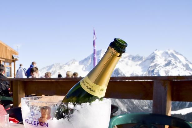 Eine Flasche Champagner im Eis vor einer Bergkulisse.