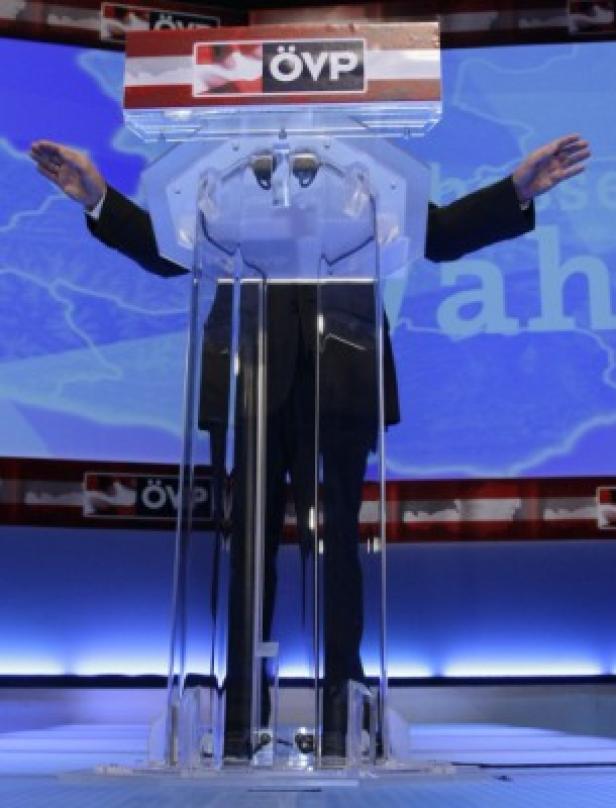 Eine Person steht hinter einem Rednerpult mit dem ÖVP-Logo und breitet die Arme aus.