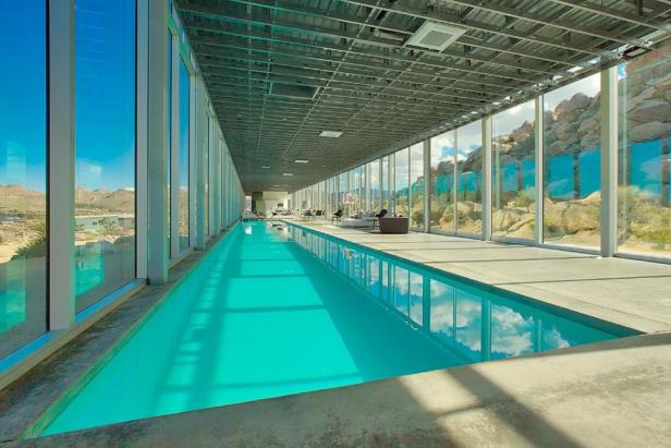 Ein langer, schmaler Pool in einem modernen Haus mit Blick auf die Wüste.