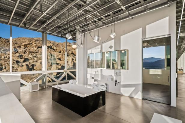 Ein Badezimmer mit Badewanne und Blick auf eine felsige Landschaft.