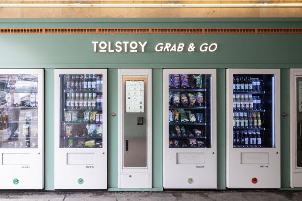 Mehrere „Tolstoy Grab & Go“-Verkaufsautomaten mit Getränken und Snacks.