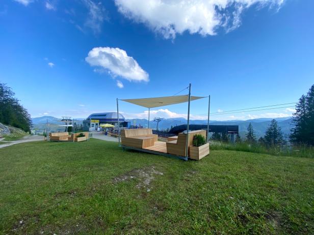 Eine Bergstation mit Sitzgelegenheiten und Blick auf die umliegenden Berge.