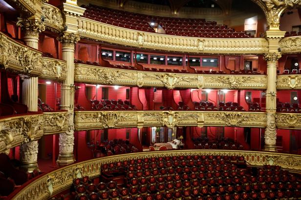 Blick in den prunkvollen Zuschauerraum eines Theaters mit roten Sitzen und goldenen Verzierungen.
