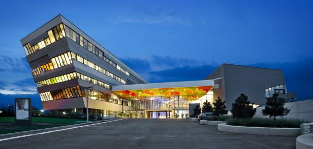 Das moderne Gebäude der Therme Laa an einem Abend mit blauem Himmel.