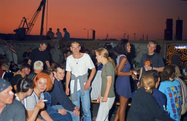 Eine Gruppe junger Leute versammelt sich im Freien bei Sonnenuntergang.