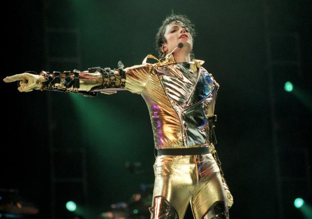Michael Jackson in goldener Bühnenkleidung während eines Auftritts.
