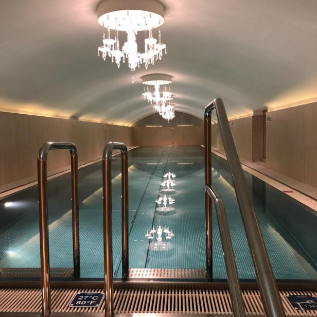 Ein Schwimmbad mit Kristalllüstern an der Decke.