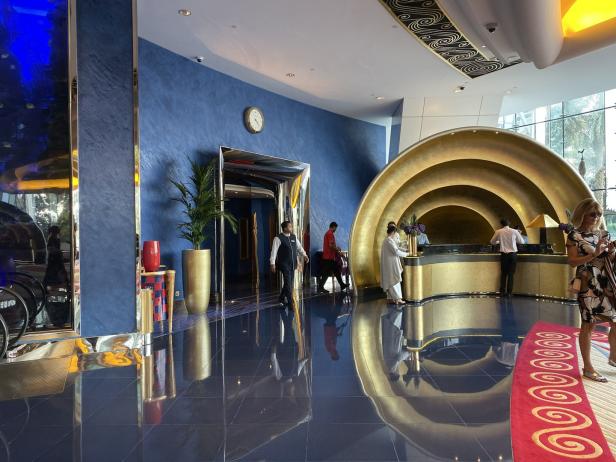 Die Lobby eines luxuriösen Hotels mit goldenen Akzenten und blauen Wänden.
