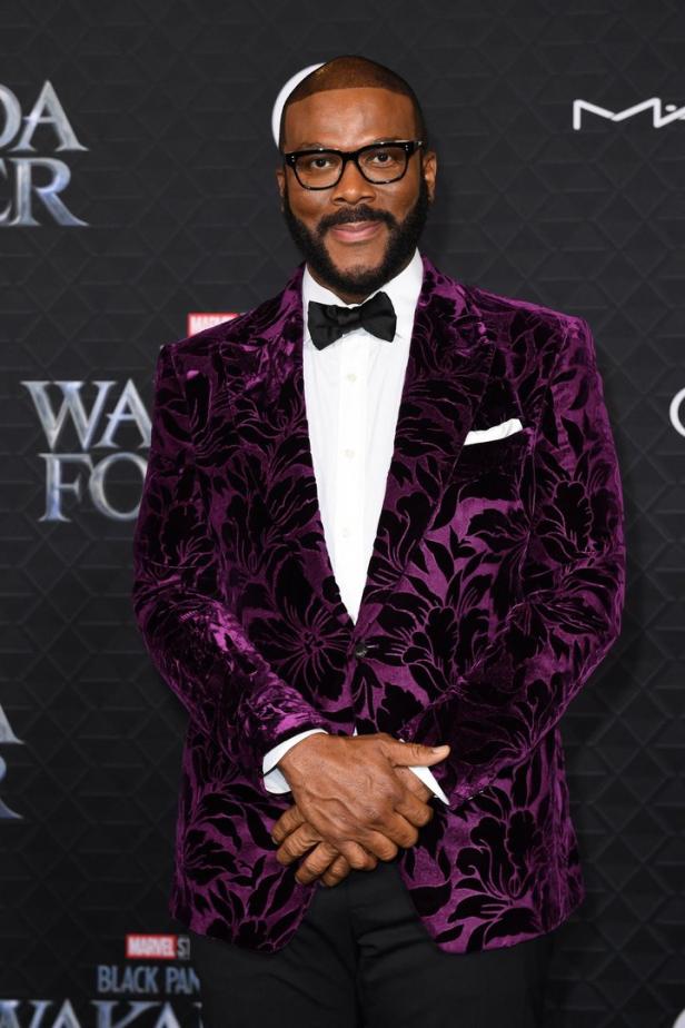 Tyler Perry trägt einen violetten Samtanzug mit Blumenmuster auf dem roten Teppich.