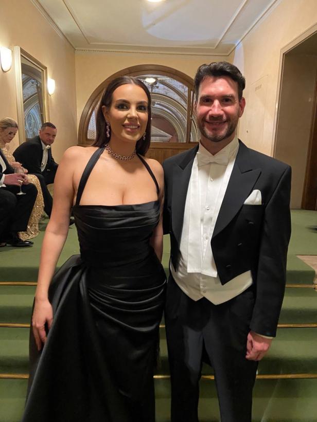 Eine Frau in Abendgarderobe und ein Mann im Smoking posieren für ein Foto.