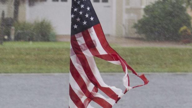 Eine beschädigte amerikanische Flagge weht im Regen.