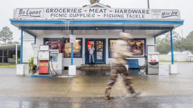 Eine Person geht bei Regen an „Bo Lynns“ Gemischtwarenladen vorbei.