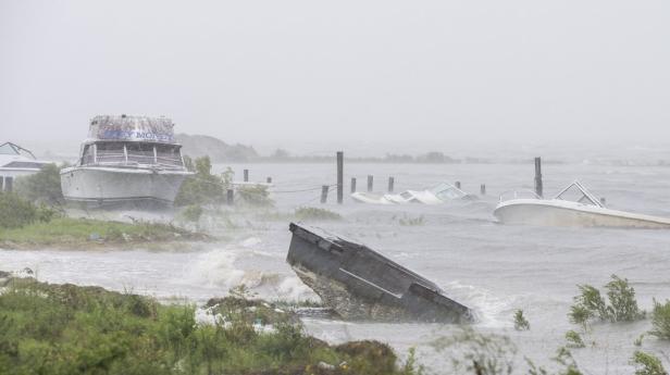 Mehrere beschädigte Boote liegen nach einem Sturm im Wasser.